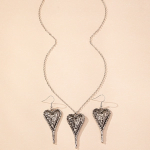 Détail d'un ensemble de bijoux coeur vintage avec finition texturée martelée à la main