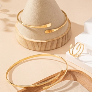 Parure de bijoux dorés avec deux bracelets ouverts et une bague ajustable assortie