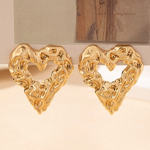 Detailed view of golden heart earrings with unique lava texture and molten metal design