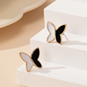 Elegant butterfly stud earrings with black and white enamel wings and golden metal trim