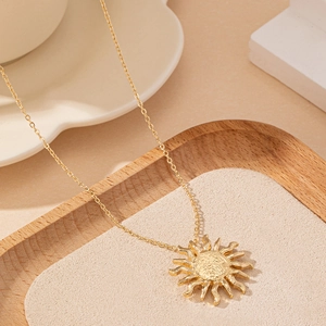 Minimalistische goldene Sonnen-Halskette mit strukturierten Strahlen an einer Goldkette