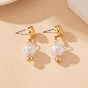 Detailed shot of gold-plated twisted hoop earrings with white round pearl drops