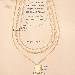 Three-layer gold layered necklace set with pearls and a polished disc pendant
