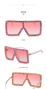 Macro view of pink oversized sunglasses with rhinestones and gradient lenses