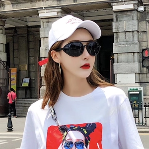 Streetstyle van een ronde punk zonnebril met lederen rand en t-shirt met kunstprint