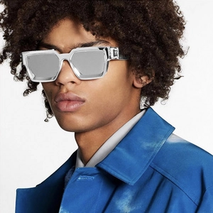 Detail of vintage square sunglasses featuring metal monogram hinges and grey acetate frames