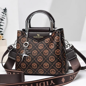 Detail of printed large capacity handbag with silver metal handles and star charm pendant