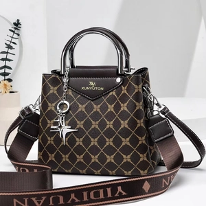 Detailed close-up of patterned brown handbag with gold star charm and fabric strap