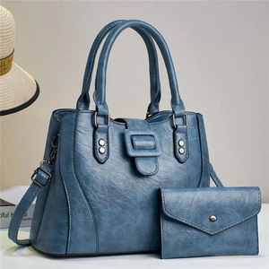 Close-up of vintage blue PU leather tote and matching envelope wallet with metal rivets