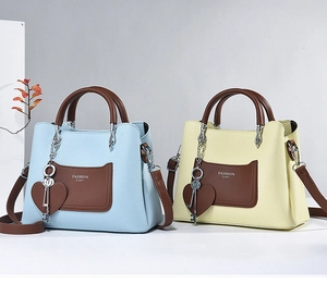 Detail of printed large capacity handbags with Fashion Queen logo and metal pendants
