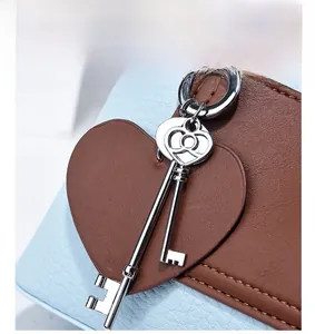 Detail of blue and brown leather handbag with heart charm and silver key pendant