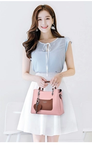 Pink lychee texture handbag featuring a brown pocket and heart-shaped leather charm detail