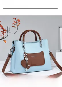 Detail of light blue lychee pattern leather tote bag with brown pocket and heart charm