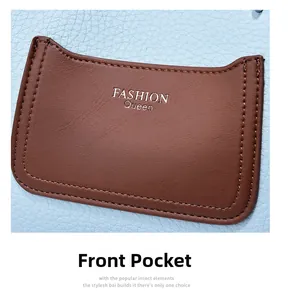 Detail of light blue pebble leather bag featuring a brown front pocket with silver lettering