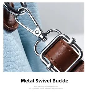 Detail of silver swivel clasp on light blue pebbled leather bag with brown trim