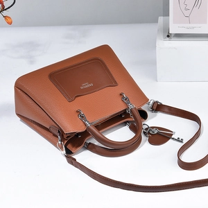 Caramel lychee grain handbag with FASHION Queen print and heart charm in a top view