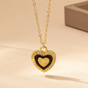 French vintage black heart pendant necklace with gold textured star in a minimalist design