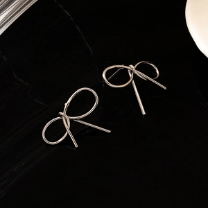 Boucles d'oreilles nœud en argent poli sur fond noir avec surface réfléchissante
