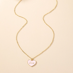 Dettaglio della collana a catena dorata con pendente a cuore in smalto rosa e scritta Love