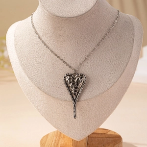 Collana con ciondolo a cuore in argento vintage con trama martellata su un manichino