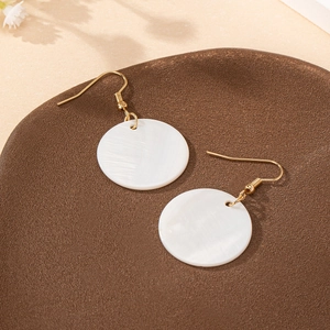 Élégantes boucles d'oreilles dorées avec pendentifs ronds en coquillage blanc style d'été