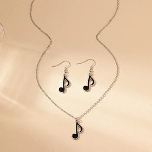 Detail view of musical note jewelry set with silver metal and black enamel finish