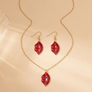 Detail of red enamel lip necklace and matching earrings set on gold plated metal