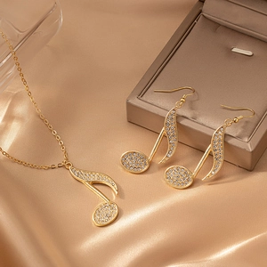 Elegant gold musical note jewelry set with sparkling rhinestones on satin background