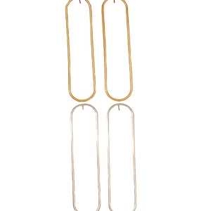 Minimalist geometric oval hoop earrings set in polished gold and silver metal finishes