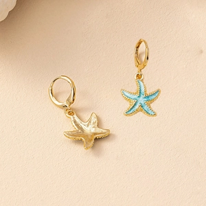 Detail of starfish drop earrings with blue enamel texture and gold-plated finish
