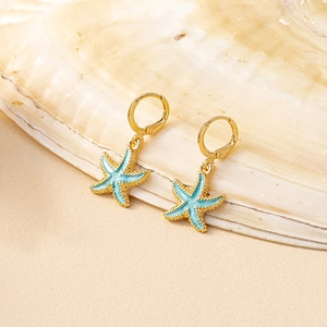 Starfish pendant earrings with light blue enamel and golden metal on a seashell