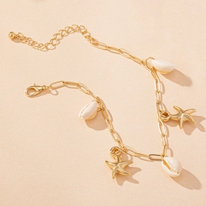 Detail of gold starfish and white seashell charms on a minimalist summer anklet chain