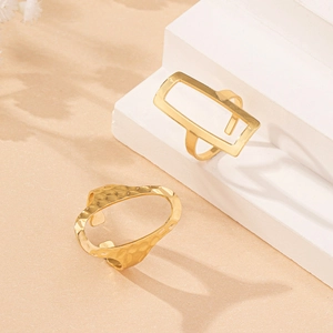 Minimalist gold geometric hollow and hammered textured rings set on white steps