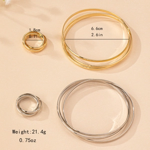 Modern gold and silver triple ring jewelry set with matching bangles on beige background