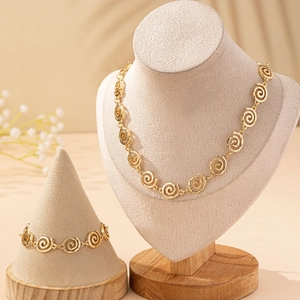 Elegant gold spiral jewelry set featuring a necklace and bracelet on display