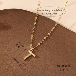 Macro shot of bamboo style letter T pendant with bark texture and 45+7cm chain size