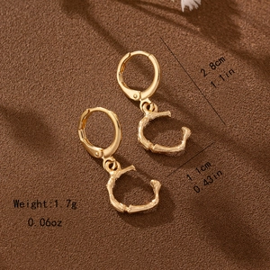 Detailed view of golden bamboo style letter C drop earring with size and weight specs