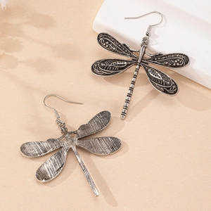 Boucles d'oreilles libellule argentées vintage avec ailes texturées en studio épuré