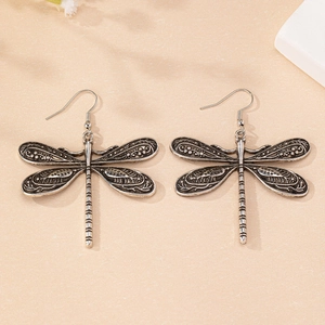 Vue détaillée des boucles d'oreilles libellule vintage avec des ailes en argent ciselé