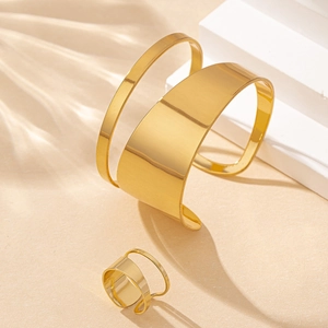 Elegant gold hollow cuff bracelet and ring set on minimalist geometric props