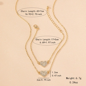 Elegant gold heart jewelry set with necklace and bracelet featuring white cubic zirconia