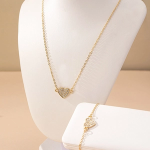 Elegant gold heart jewelry set featuring sparkling rhinestone necklace and bracelet
