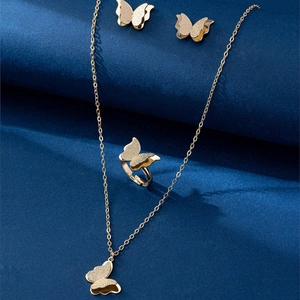 Détail macro d'une parure papillon en or mat avec collier texturé et bague réglable