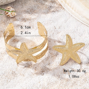 Golden starfish cuff bracelet and ring set with textured hammer finish on white beach sand
