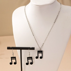 Détail d'un ensemble bijoux note de musique argenté avec émail noir sur supports élégants