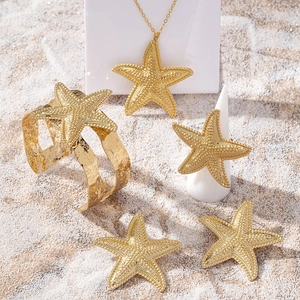 Parure de bijoux étoile de mer dorée avec collier bracelet et bague sur sable