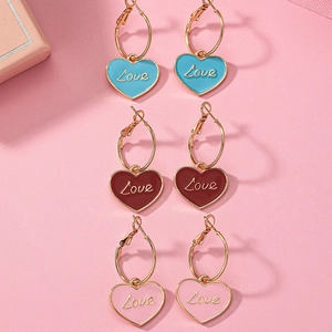 Tre paia di orecchini a cuore dorati con scritta Love in blu, rosso e rosa