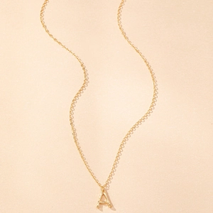 Gold bamboo texture letter A pendant necklace with thin chain on minimalist background