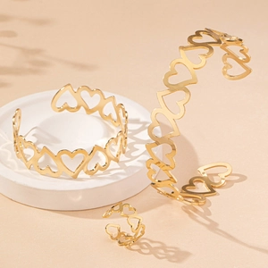 Elegant gold hollow heart jewelry set featuring open bangles and a matching ring
