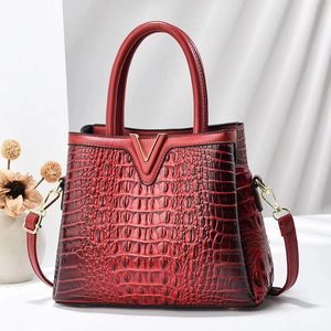 Glossy red crocodile texture handbag with gold V buckle and adjustable shoulder strap